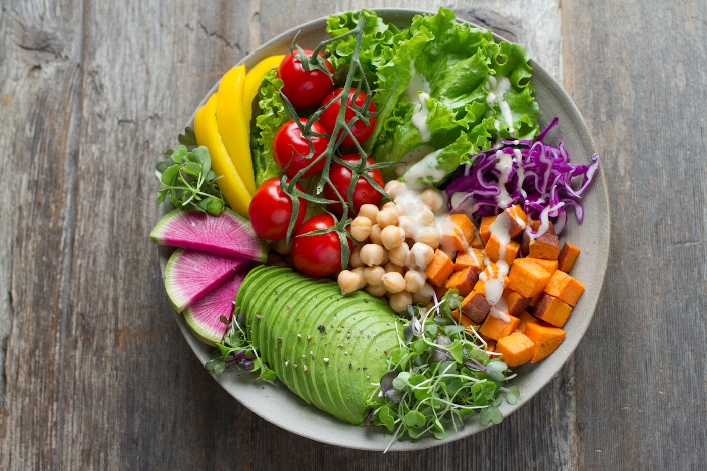 A colorful bowl of fresh vegetables, chickpeas, and avocado